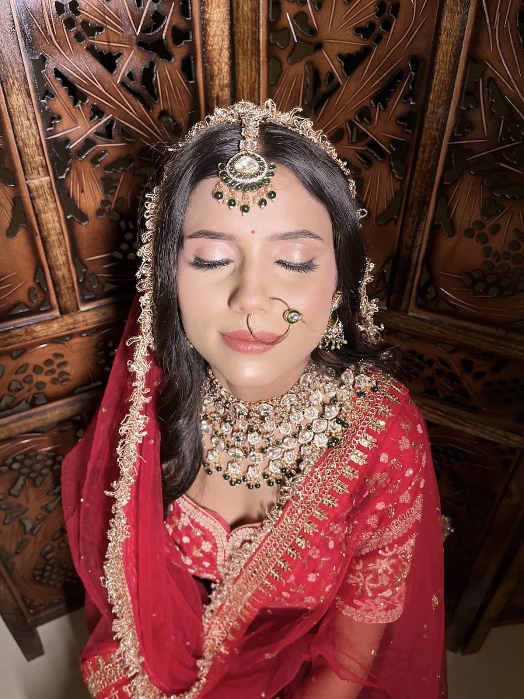 Bride with eyes closed showcasing shimmer eye makeup and polki jewellery