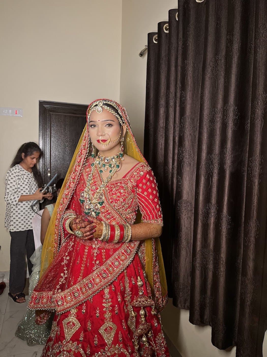Bride fully ready inside the studio in a red lehenga